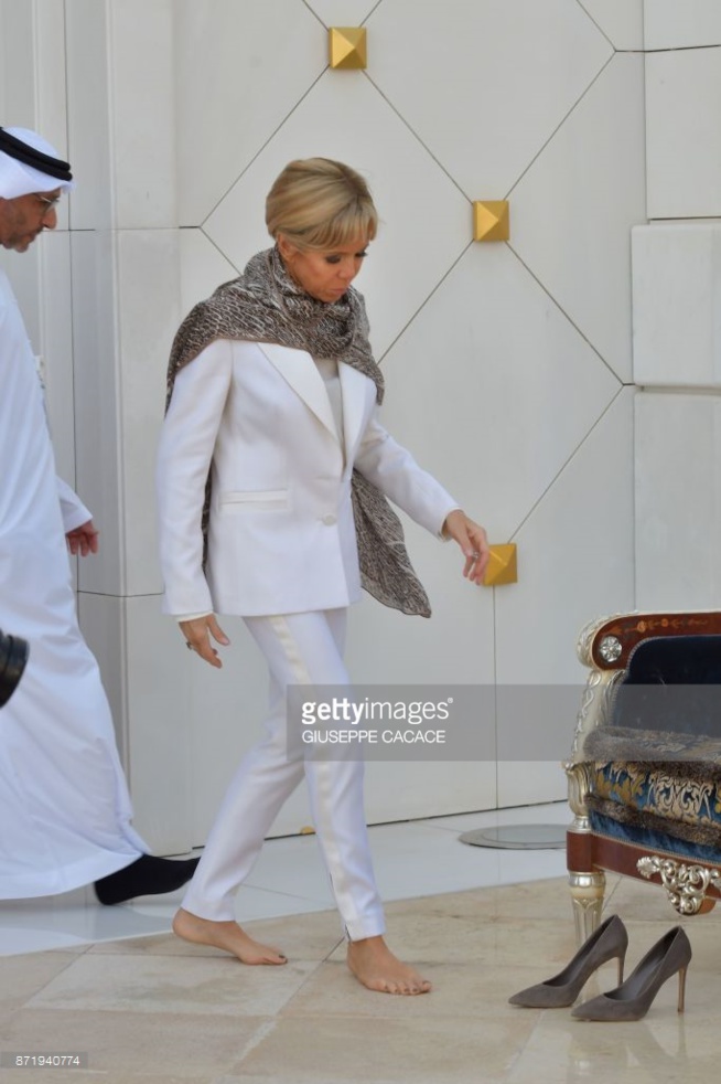 En voyage à Abu Dhabi, Brigitte Macron enlève ses chaussures, troque ses robes courtes pour une…