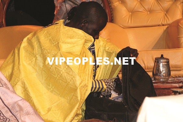 Le petit frère de Alassane Mbaye avec une valise remplie de billets de banque