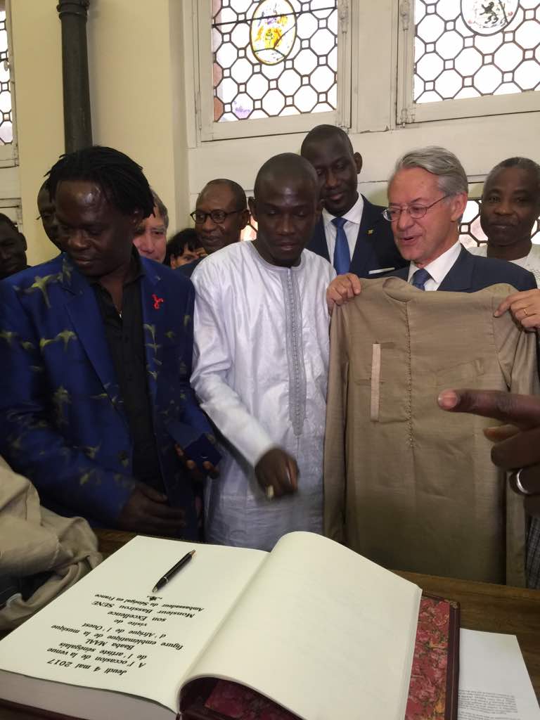 Le président de l'ADESMATS (Association des maitre tailleurs du Senegal) Moustapha Fall Bara Couture décore Baba Maal et le Maire de Compégne.