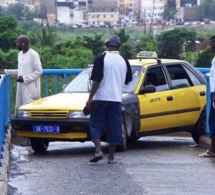 Des taxis prennent la passerelle des piétons sur l'autoroute à péage